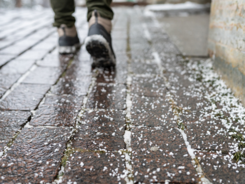 person som går på fortau de det er saltet mot glatt føre person som går på fortau de det er saltet mot glatt føre