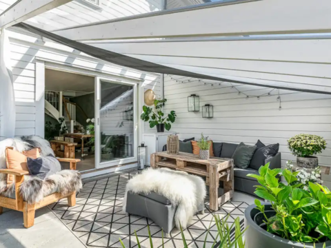 Terrasse med hagemøbler og hyggelig sone under tak